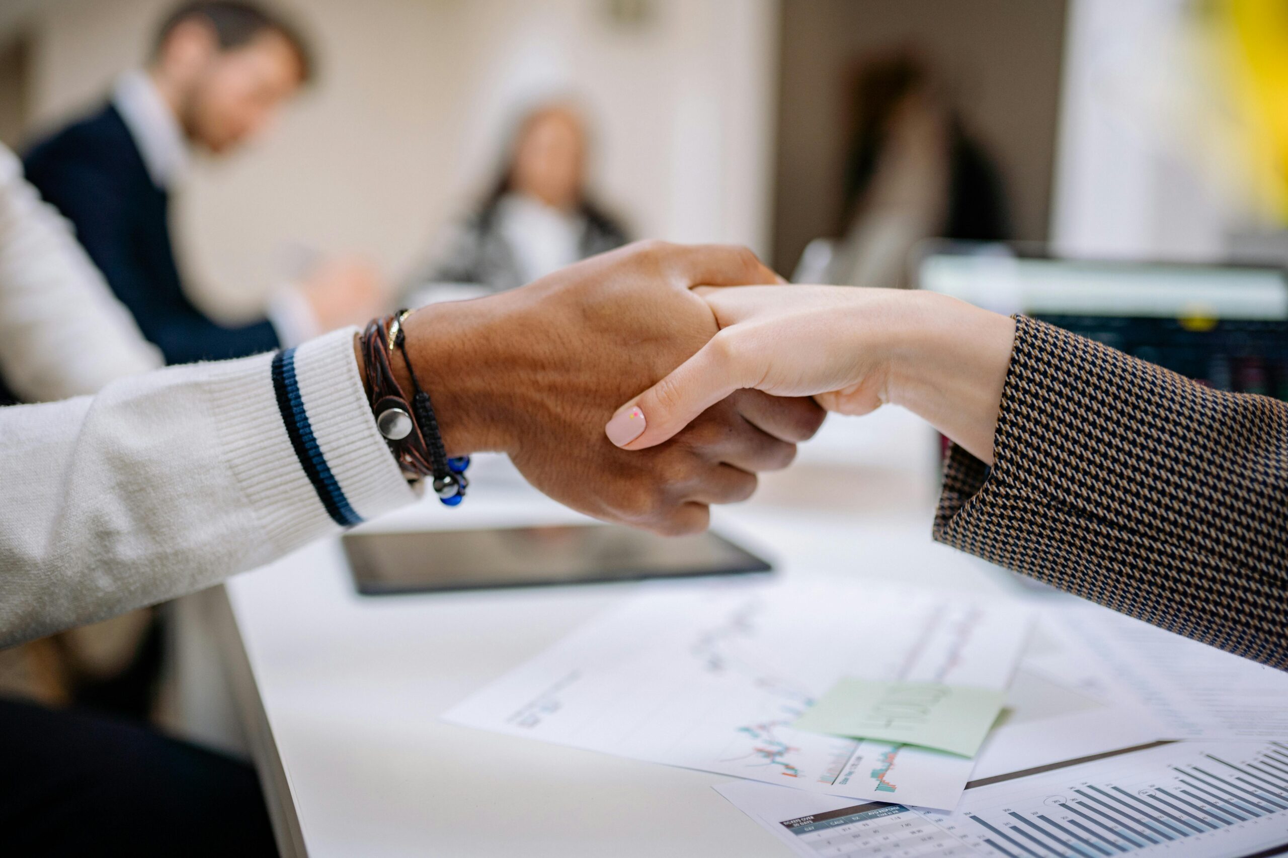 B2B Moving (Business2Business) Diverse business professionals exchanging handshake in an office environment, symbolizing agreement.